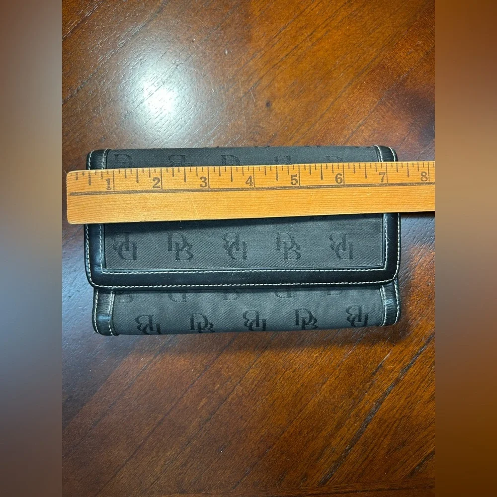 Dooney & Bourke Black Logo Fold Wallet It has a small detail on the inside